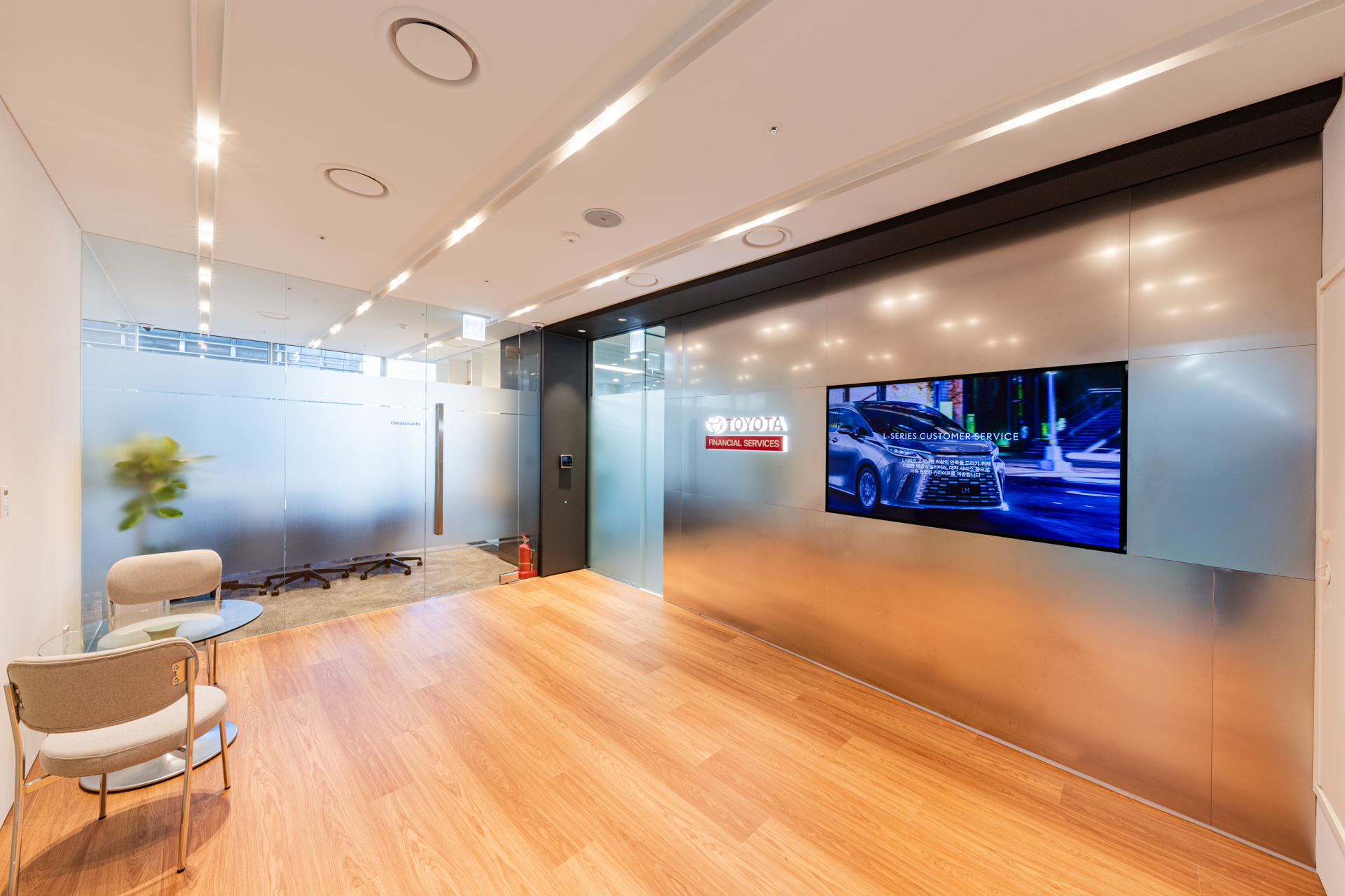 토요타파이낸셜서비스코리아 오피스 리셉션 앞 내부 복도 공간, 금속 패널 벽면과 디지털 디스플레이가 있는 모던한 분위기. 시드나인(SIDnine) 디자인·시공 인테리어.