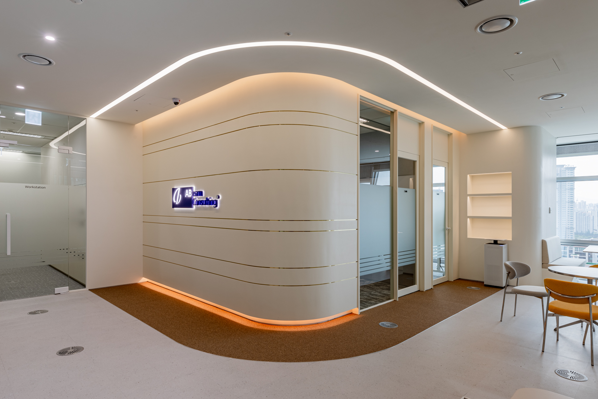 시드나인(SIDnine)이 설계 및 시공한 아빔 컨설팅(Abeam Consulting) 오피스 입구 공간. 부드러운 곡선의 벽체와 브랜드 로고월이 인상적임